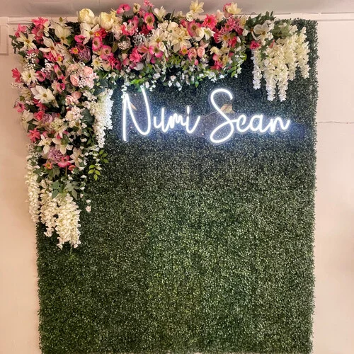 Numi Scan neon sign on a floral wall at the Gosforth baby scan clinic